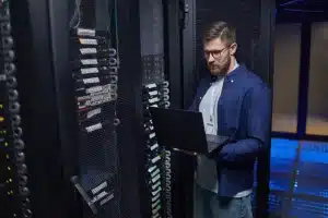 Technicien informatique inspectant des serveurs pour assurer la reprise d’activité des PME en Normandie