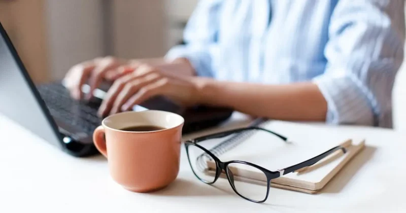 Télétravail sécurisé pour PME normandes – salarié travaillant à domicile sur ordinateur portable avec café et carnet