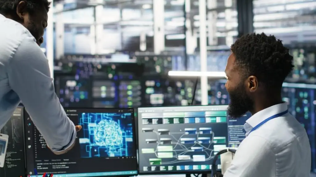 Ingénieurs informatiques analysant un réseau serveur et une interface d’intelligence artificielle – Supervision IT pour PME en Normandie.